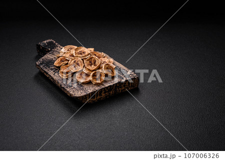 Round slices of sweet banana on a dark concrete background 107006326