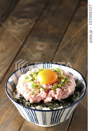刻み海苔と卵黄とネギトロの丼ぶりを単品撮影 107006327