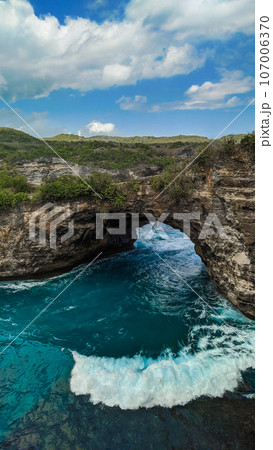 Majestic cliffs surround a serene turquoise bay at Broken Beach, Nusa Penida Majestic cliffs surround a serene turquoise bay at Broken Beach, Nusa Penida 107006370