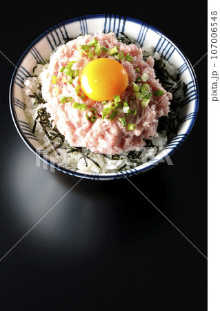 刻み海苔と卵黄とネギトロの丼ぶりを黒背景で俯瞰撮影 刻み海苔と卵黄とネギトロの丼ぶりを黒背景で俯瞰撮影 107006548