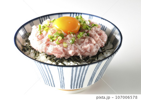 刻み海苔と卵黄とネギトロの丼ぶりを白背景で撮影 107006578