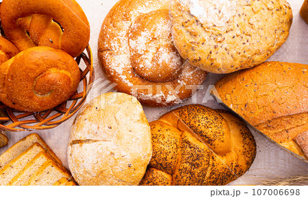 Lot of different flavored bread, wheat, rye, on the table in the field outside Lot of different flavored bread, wheat, rye, on the table in the field outside 107006698