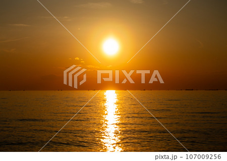 東京湾のさざ波に揺れる夕焼けの太陽の光の写真素材 [107009256] - PIXTA