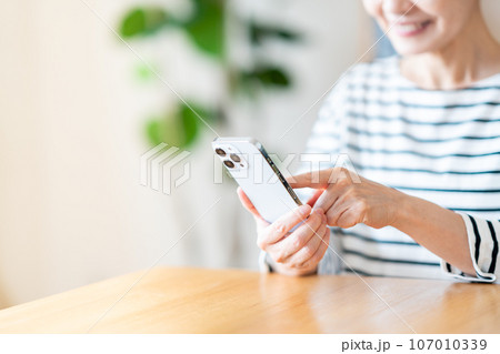 スマートフォンを操作するシニア女性（パーツモデル） 107010339