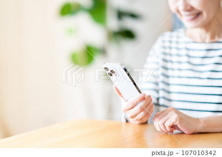 スマートフォンを操作するシニア女性（パーツモデル） 107010342