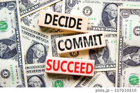 Decide commit succeed symbol. Concept word Decide Commit Succeed on beautiful wooden block. Dollar bills. Beautiful dollar bills background. Business decide commit succeed concept. Copy space. 107010810