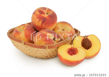 Ripe peach fruit with half in a wicker basket isolated on white background with full depth of field 107011035