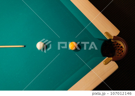Billiard accessories balls and cue on a billiard table 107012146
