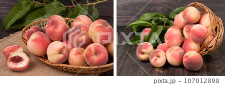peaches in a wicker basket with leaves on wooden table 107012898