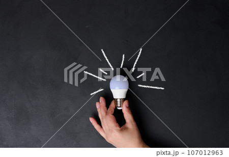 A woman's hand holds an electric lamp, the concept of searching for new ideas, startup 107012963