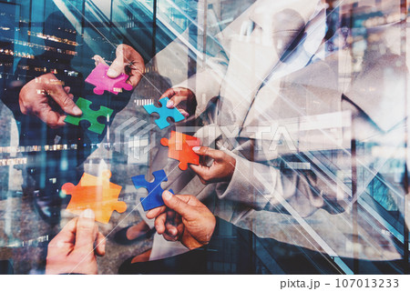 Businessmen working together to build a puzzle as teamwork, partnership and integration concept 107013233