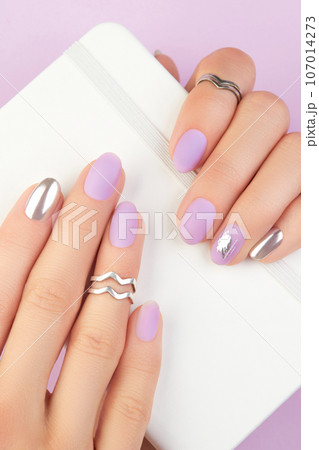 Close up womans hands with matte lavender and silver nails. Beauty treatment 107014273