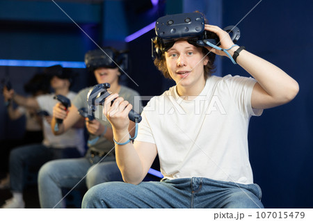 Surprised man looking at camera with enthusiastic eyes after playing virtual game Surprised man looking at camera with enthusiastic eyes after playing virtual game 107015479