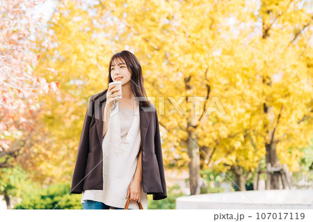 紅葉の季節にコーヒーを飲む女性 107017119