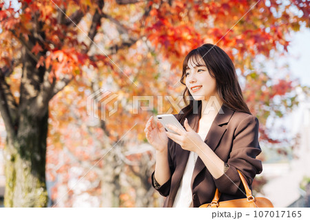 紅葉の季節にお出かけをする女性 紅葉の季節にお出かけをする女性 107017165