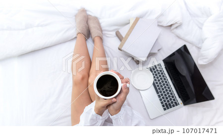 Asian woman in bedroom drinking coffee after wake up and relax mood in holiday near window, Asian woman in bedroom drinking coffee after wake up and relax mood in holiday near window, 107017471