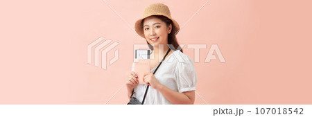 Young Asian woman with passport and ticket on pink background with space for text for banner Young Asian woman with passport and ticket on pink background with space for text for banner 107018542