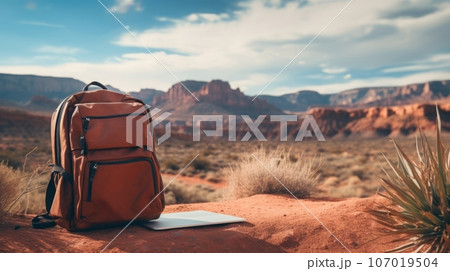A laptop and a backpack in front of a scenic landscape, representing the lifestyle of remote workers and digital nomads. A laptop and a backpack in front of a scenic landscape, representing the lifestyle of remote workers and digital nomads. 107019504
