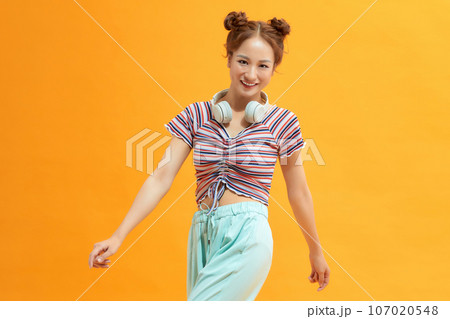 Carefree young woman enjoying favorite song, dancing and feeling free and happy. 107020548