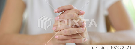 Close up of female hands on open book. Close up of female hands on open book. 107022323