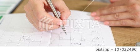 Business woman checks her planner and takes notes in organizer. 107022490