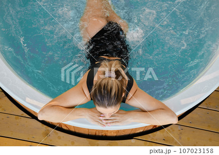 Unrecognizable woman relaxing in the hot tub Unrecognizable woman relaxing in the hot tub 107023158