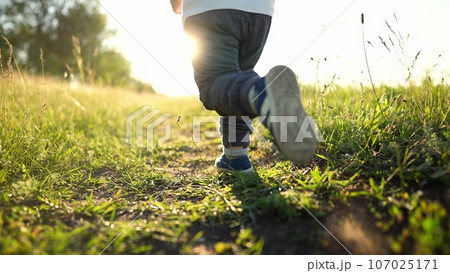 kid run legs close-up in the park at sunset. happy family. people in the park concept boy son joyful run. happy family summer. little baby run child fun summer kid lifestyle dream concept 107025171