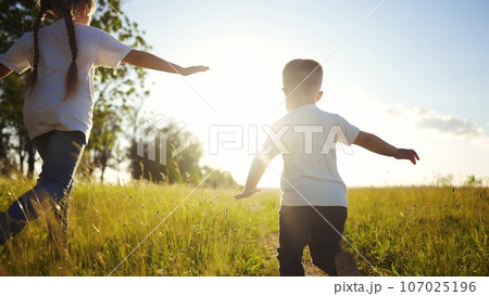 happy family kids. people in the park children child running together in the park at sunset silhouette. mom dad daughter and son are run happy family and little child in summer. dream fun kids run 107025196