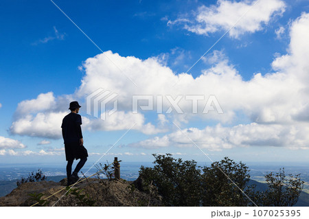 筑波山の山頂に到着して街を見下ろす男性 107025395