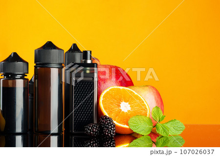 Vape smoking liquid with fruit flavor on orange background Vape smoking liquid with fruit flavor on orange background 107026037