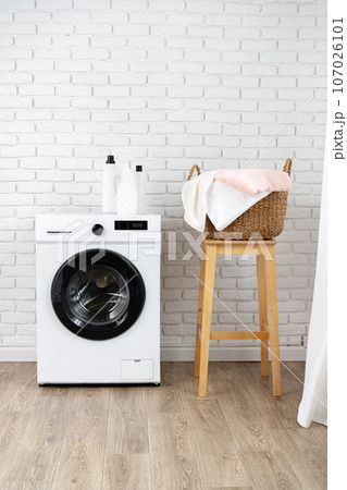 Laundry room with washing machine and basket with laundry Laundry room with washing machine and basket with laundry 107026101