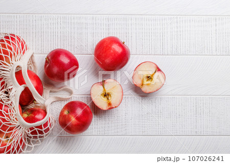 Mesh bag with fresh red apples 107026241