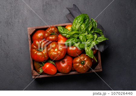 Assorted tomatoes in rustic crate 107026440