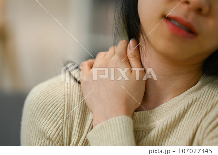 Cropped shot of young woman massaging her neck suffering from ache. Health care and problem concept 107027845