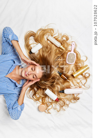 Beautiful young girl with perfect, healthy blonde hair over white background. Hair products for professional care and treatment 107028622