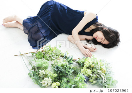花束の横で寝る若い女性 107028963