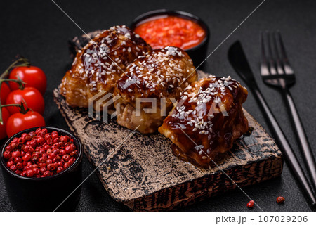 Delicious juicy fried chicken with sweet and sour teriyaki sauce and sesame seeds Delicious juicy fried chicken with sweet and sour teriyaki sauce and sesame seeds 107029206
