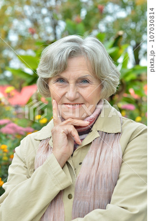 Senior woman walking in the park in autumn Senior woman walking in the park in autumn 107030814