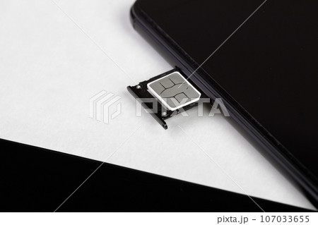 SIM card inserted into the sim card tray of a smartphone SIM card inserted into the sim card tray of a smartphone 107033655