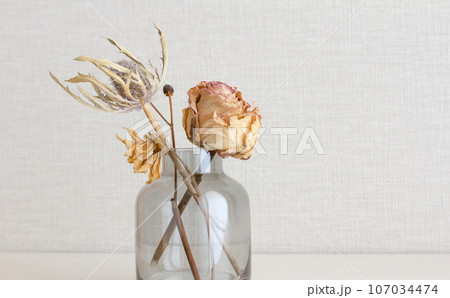 バラなどのドライフラワーと花瓶とテクスチャのある白い壁 バラなどのドライフラワーと花瓶とテクスチャのある白い壁 107034474