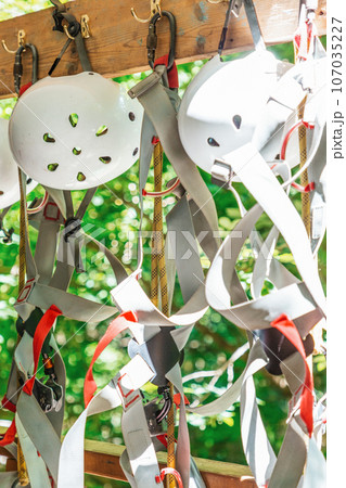 Climbing equipment. White helmets, seat belts, carabiners with ropes. Nobody 107035227