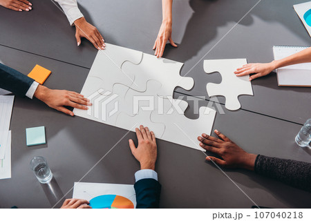Businessmen working together to build a puzzle as teamwork, partnership and integration concept 107040218