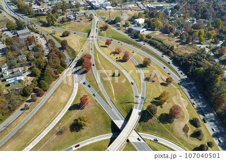 American freeway intersection in Asheville, North Carolina with fast driving cars and trucks in autumnal season. View from above of USA transportation infrastructure American freeway intersection in Asheville, North Carolina with fast driving cars and trucks in autumnal season. View from above of USA transportation infrastructure 107040501