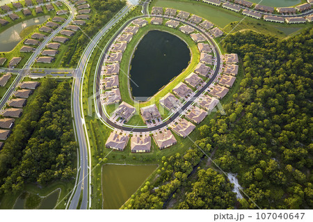 Aerial view of tightly located family houses with retention ponds to prevent flooding in Florida closed suburban area. Real estate development in american suburbs 107040647