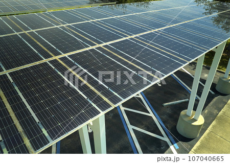 Aerial view of solar panels installed as shade roof over parking lot for parked cars for effective generation of clean electricity. Photovoltaic technology integrated in urban infrastructure 107040665