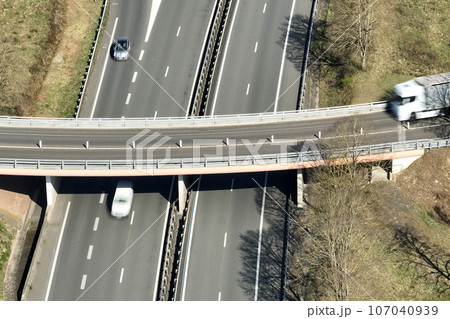 Aerial view of highway road intersection with fast moving heavy traffic. Intercity transportation with many cars and trucks 107040939