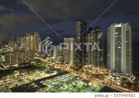 Aerial view of downtown district in Sunny Isles Beach city in Florida, USA. Brightly illuminated high skyscraper buildings in modern american midtown 107040982