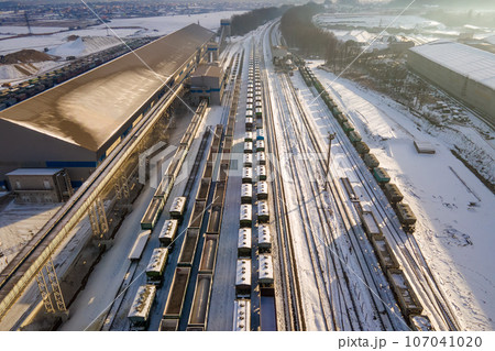 Aerial view of cargo train loaded with crushed stone materials at mining factory. Railway transportation of grinded limestone ore Aerial view of cargo train loaded with crushed stone materials at mining factory. Railway transportation of grinded limestone ore 107041020