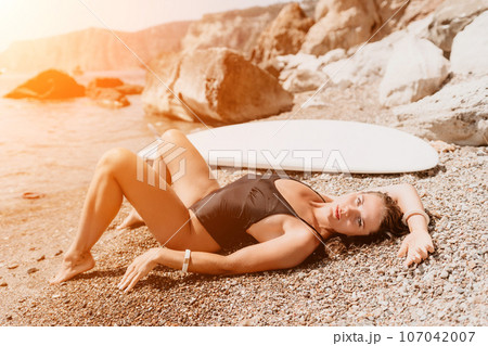 Woman sea sup. Close up portrait of happy young caucasian woman with long hair looking at camera and smiling. Cute woman portrait in bikini posing on sup board in the sea Woman sea sup. Close up portrait of happy young caucasian woman with long hair looking at camera and smiling. Cute woman portrait in bikini posing on sup board in the sea 107042007