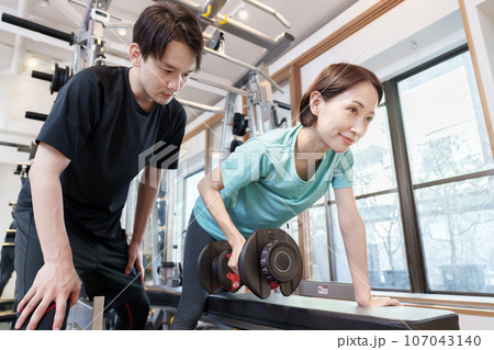 パーソナルジムでトレーニングを受ける女性 パーソナルジムでトレーニングを受ける女性 107043140